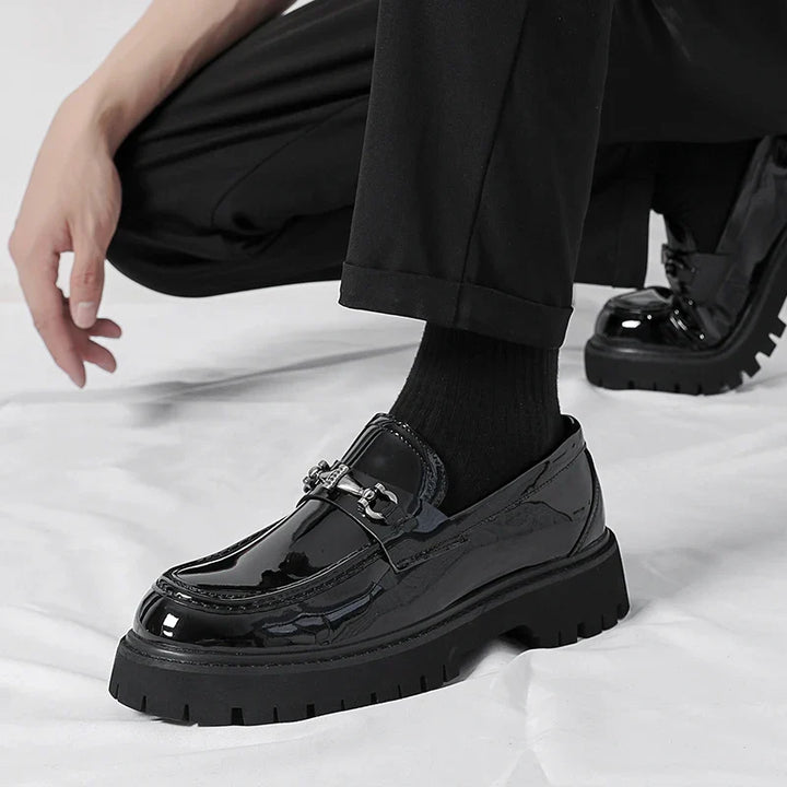 Women's leather dress loafers in black on neutral surface showing polished finish