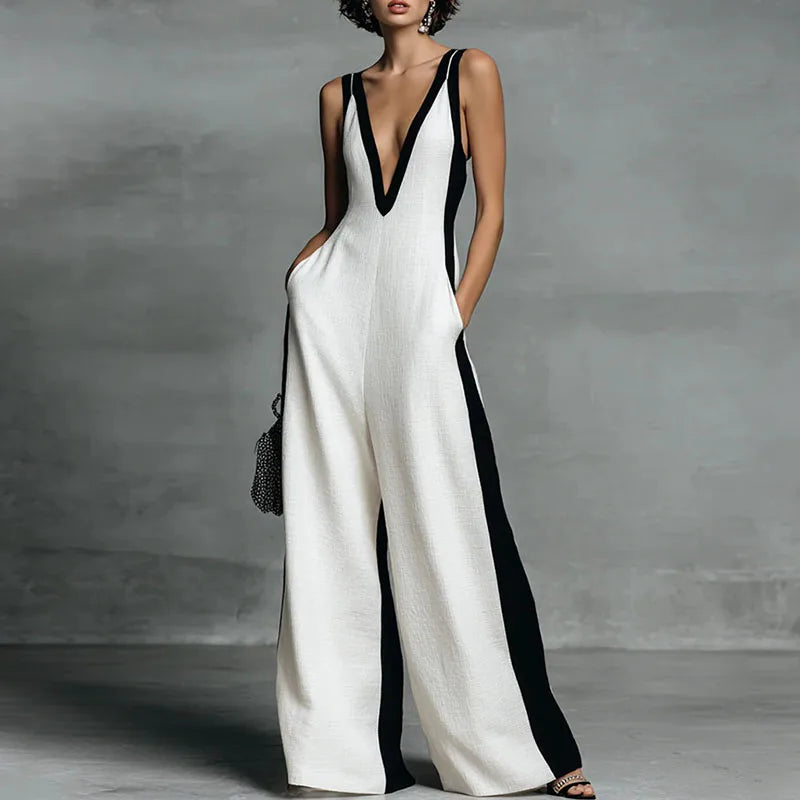 Model wearing wide leg jumpsuit with deep V neckline and contrast black side panels in white