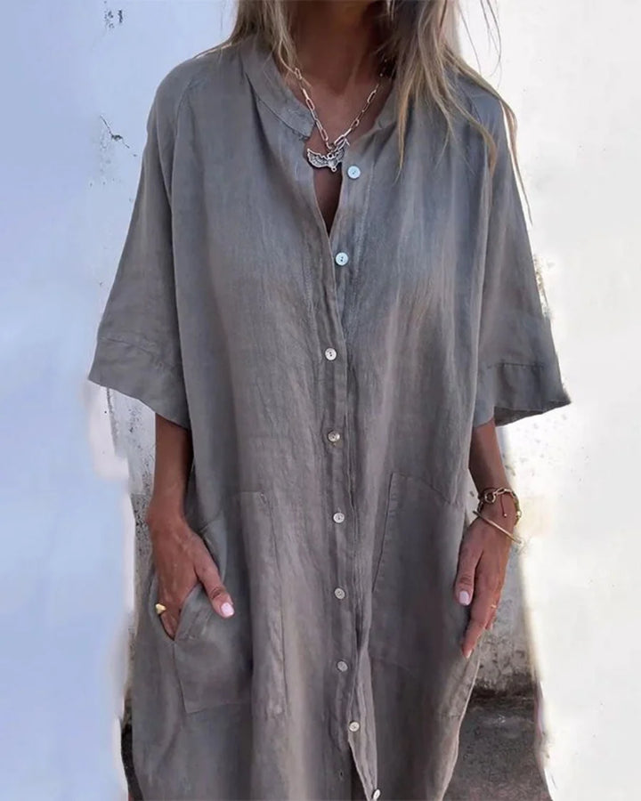 Woman wearing grey cotton summer dress shirt with button-front closure and relaxed midi-length silhouette