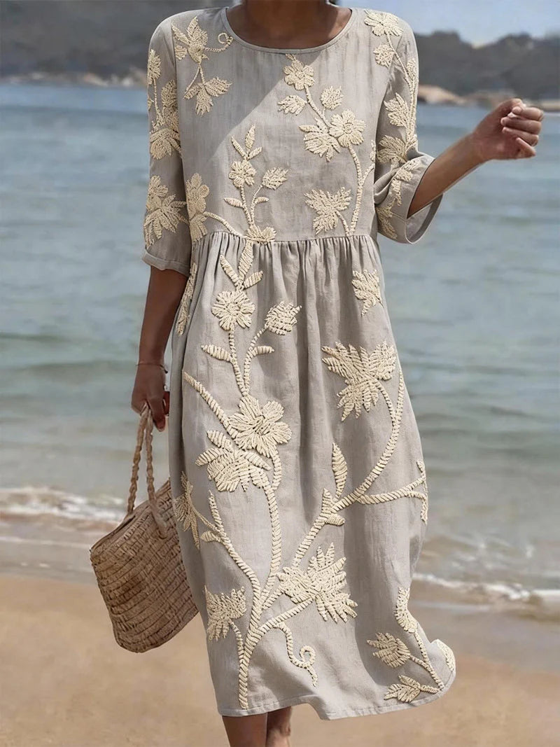 Detail shot of the three-quarter sleeves and embroidered floral motifs on the Elegant Embroidered Midi Dress