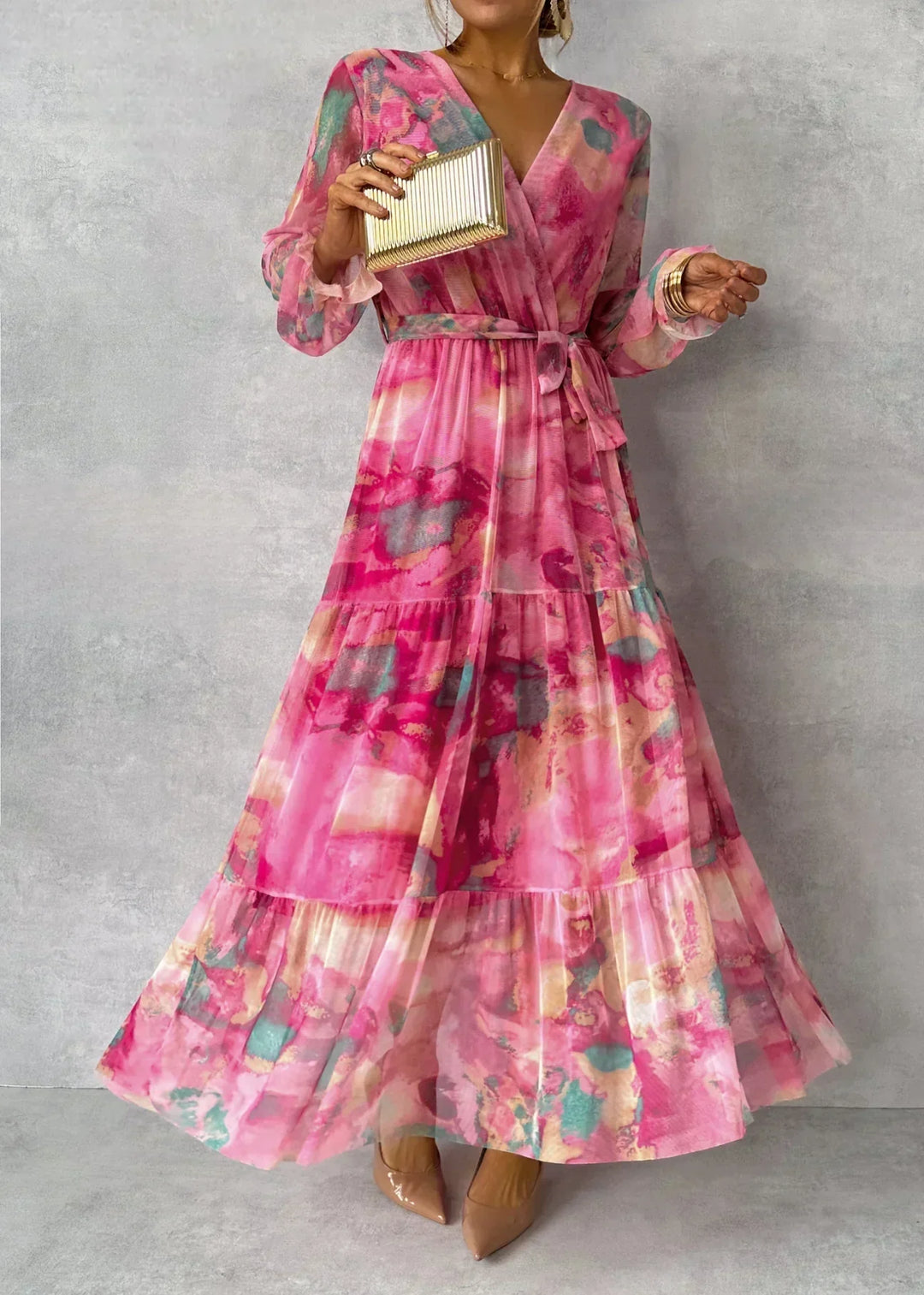 Floral wrap maxi dress with long sleeves, V-neckline, and tiered skirt in pink and peach tones