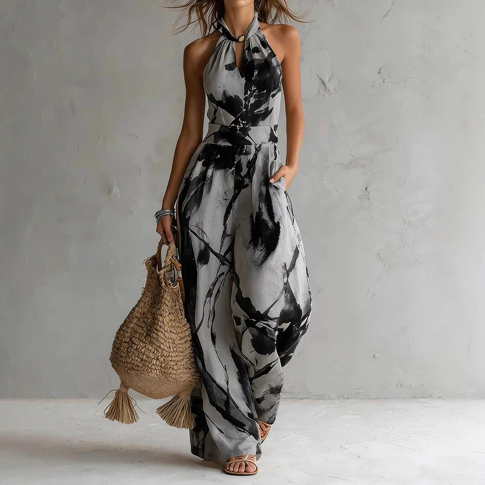 Side view of flowy halter maxi dress with artistic navy and cream print and relaxed drape