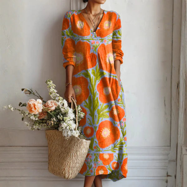 Linen Floral Dress with bold orange and green abstract print, V-neckline, three-quarter sleeves, relaxed midi silhouette on model holding woven basket