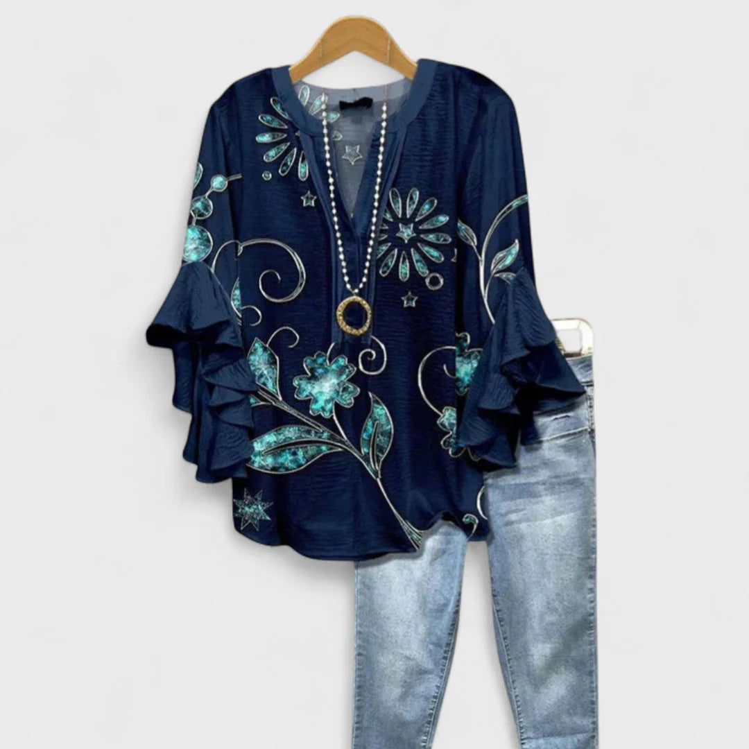 Detail of floral print pattern and ruffle sleeve panels on women's v-neck blouse