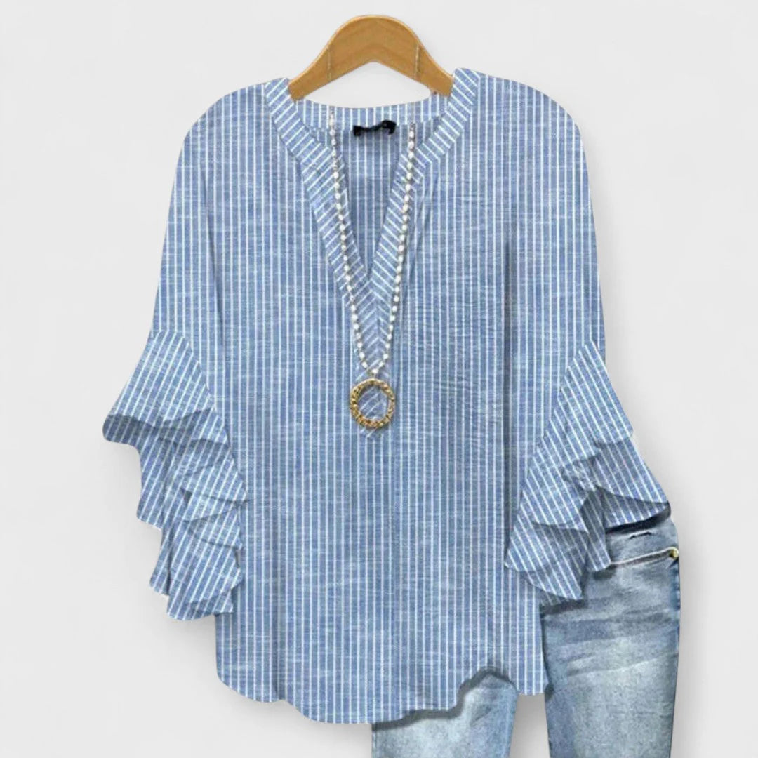 Women's v-neck blouse with layered ruffle sleeves displayed with light wash denim jeans