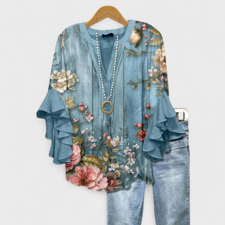 Women's botanical print blouse with ruffle sleeve detail and smooth fabric finish