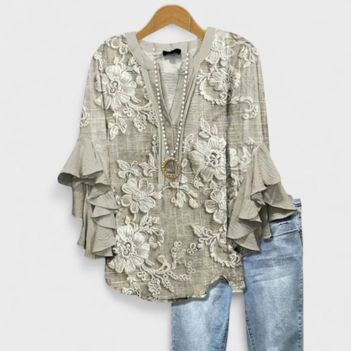 Front view of floral print blouse with v-neck opening and layered ruffle sleeve construction