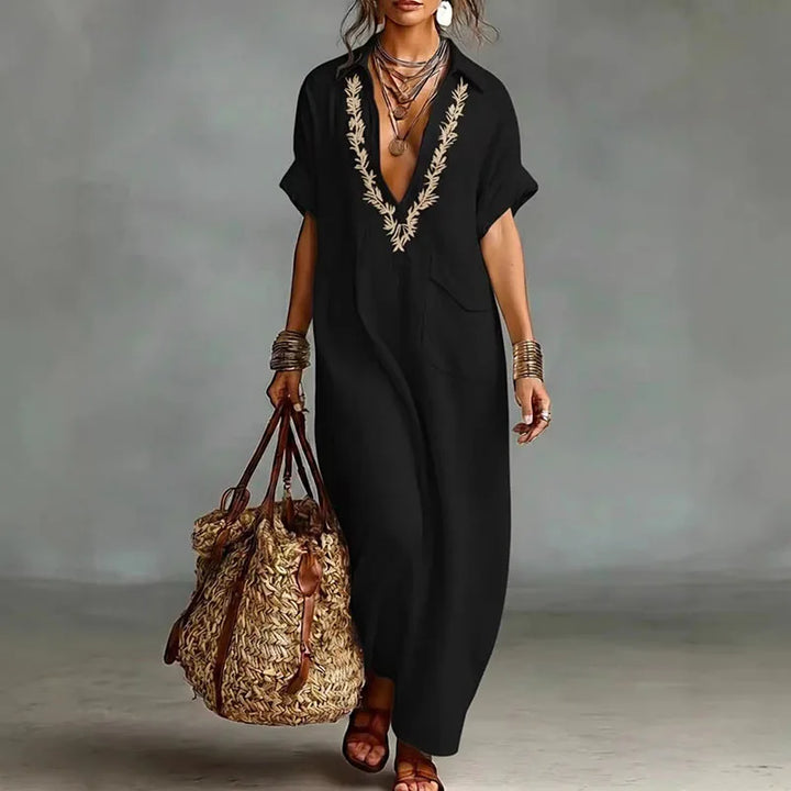 Detail shot of embroidered V neckline on kaftan dress with artisanal stitching pattern