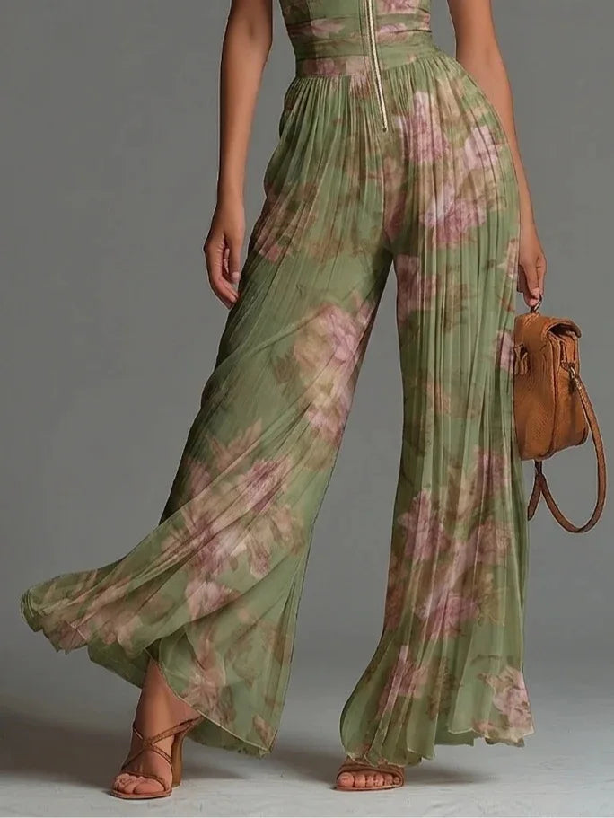 Close-up of pleated texture and floral print detail on halter neckline wide leg jumpsuit in soft green hues