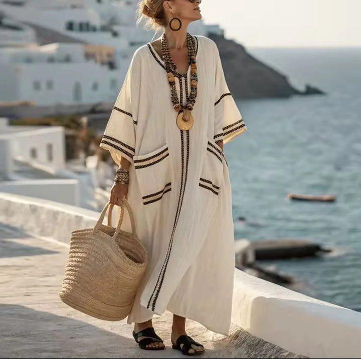 Full-length view of ankle-length striped maxi dress with front pocket and flowing drape