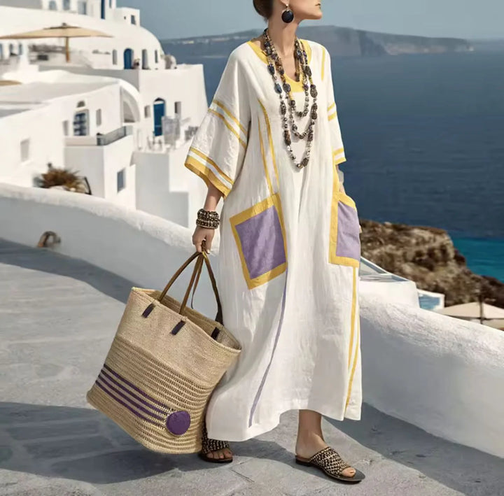 Woman styling striped maxi dress with statement jewelry and woven tote for resort wear