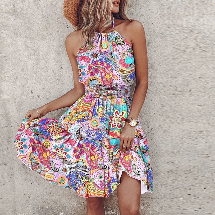 Full-length view of flowy halter neck summer mini dress with colorful printed pattern and mid-thigh length