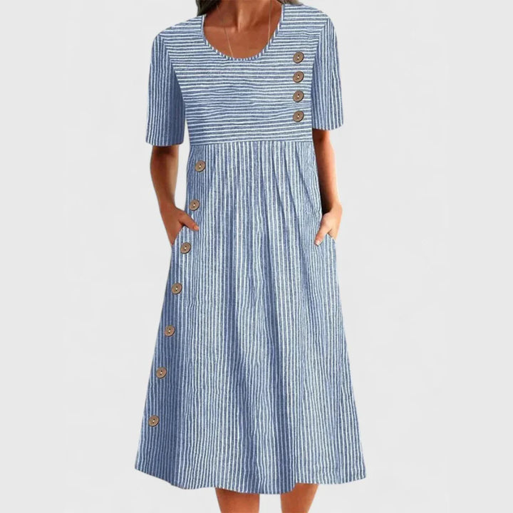 Woman wearing blue and white striped midi cotton summer dress with side button detail and short sleeves
