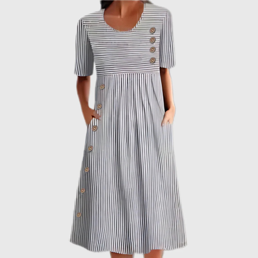 Close-up view of striped cotton summer dress showing gathered waist and wooden button closure detail