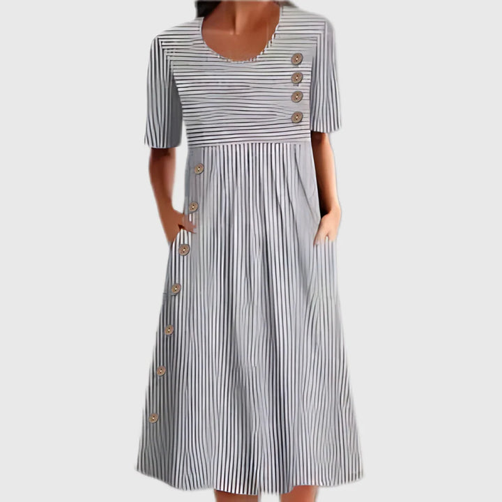 Close-up view of striped cotton summer dress showing gathered waist and wooden button closure detail