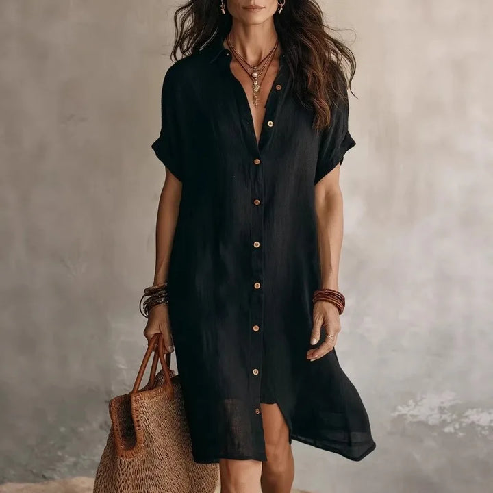 Woman wearing black button down shirt dress with relaxed fit and short sleeves for casual summer styling