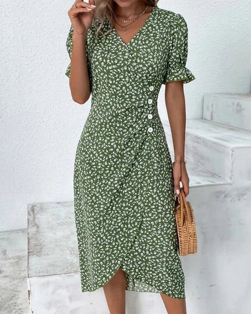 Woman wearing a green floral cotton summer dress with V-neckline and flutter sleeves in a midi length