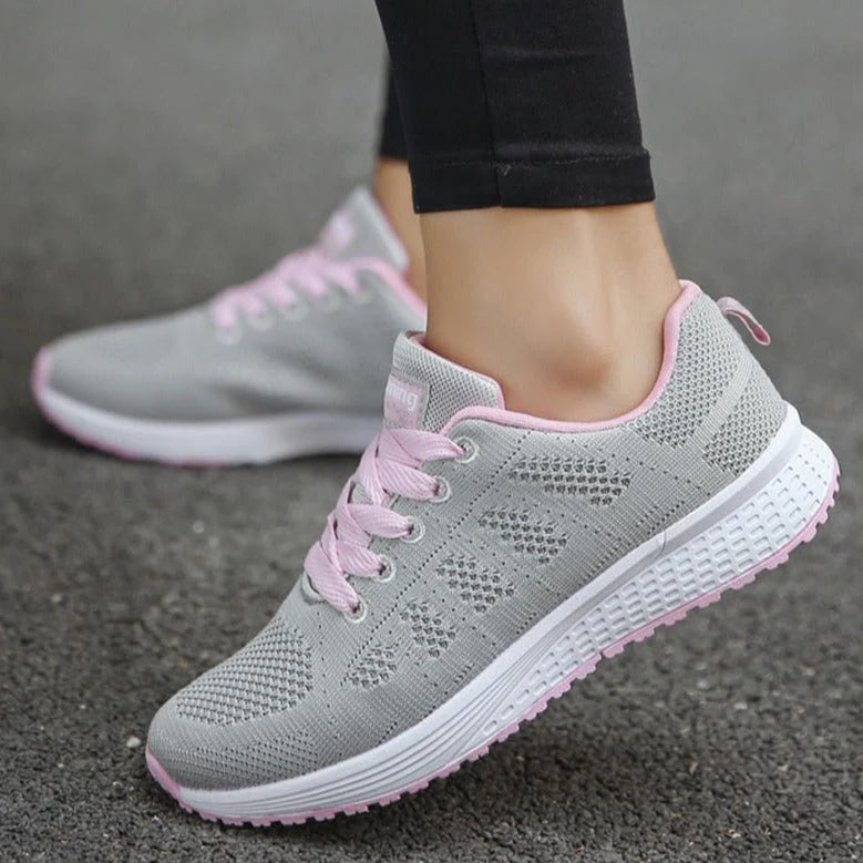Side profile of white walking shoes with textured sole and elastic mesh upper for all-day comfort