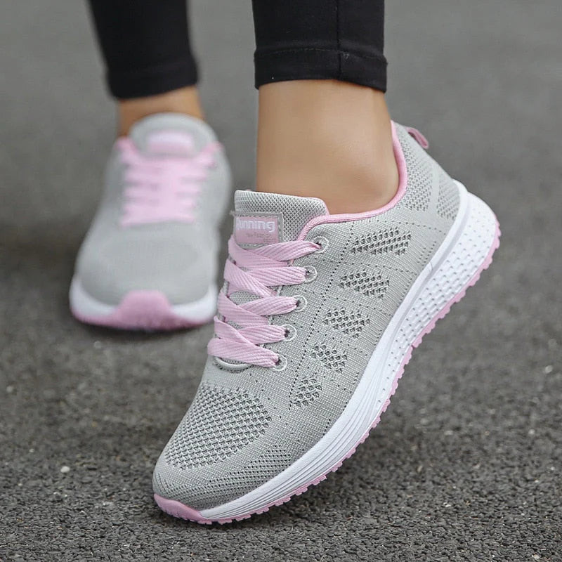 Full view of white orthopedic walking shoes showing mesh construction and shock-absorbing sole design