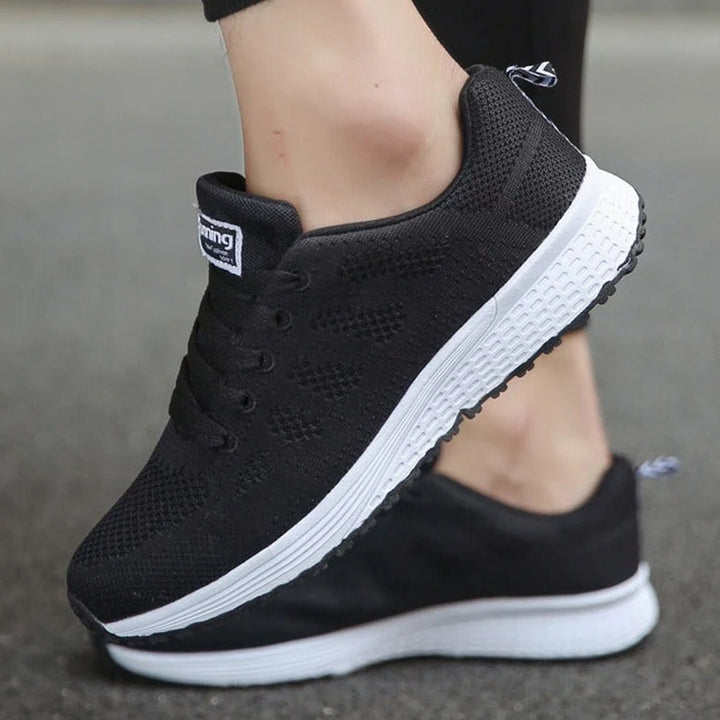 Women's orthopedic walking sneakers styled with black leggings showing textured grip sole and supportive fit