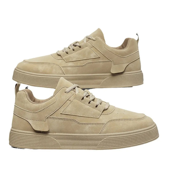 Close-up of men's low-top sneakers displaying tonal stitching and perforated detailing on upper