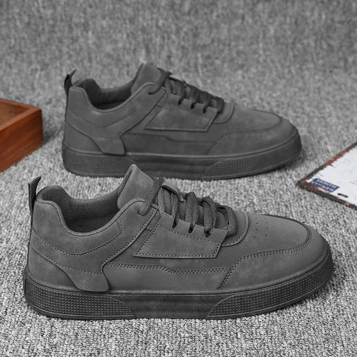 Angled view of men's taupe sneakers with smooth synthetic upper and lace-up front