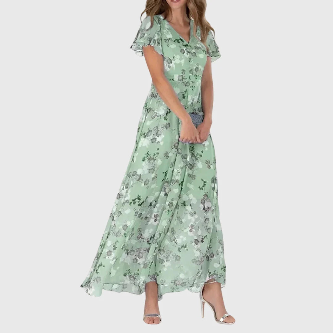 Detail of floral print pattern on coral maxi dress with V-neckline and flutter sleeves