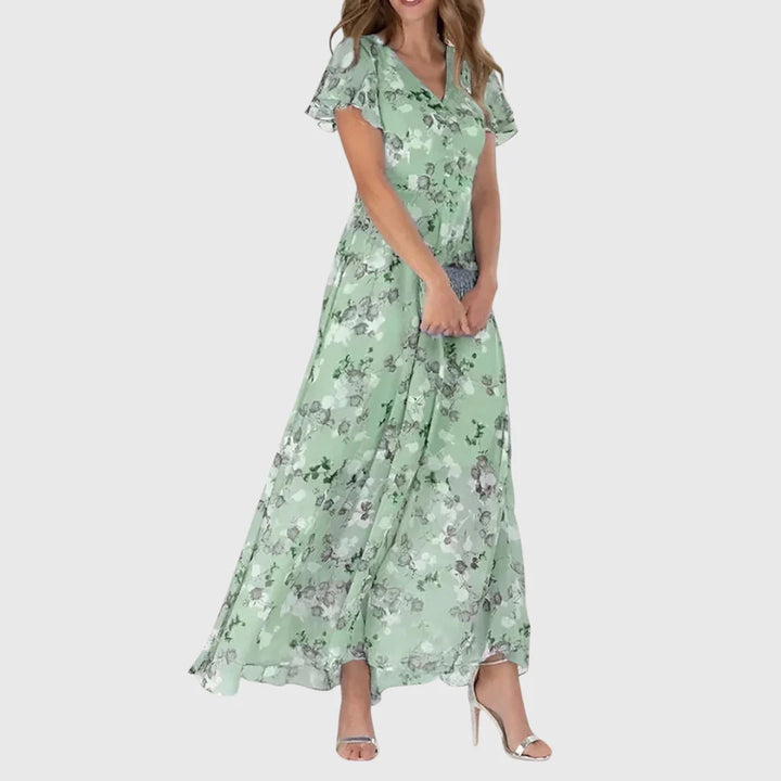 Detail of floral print pattern on coral maxi dress with V-neckline and flutter sleeves