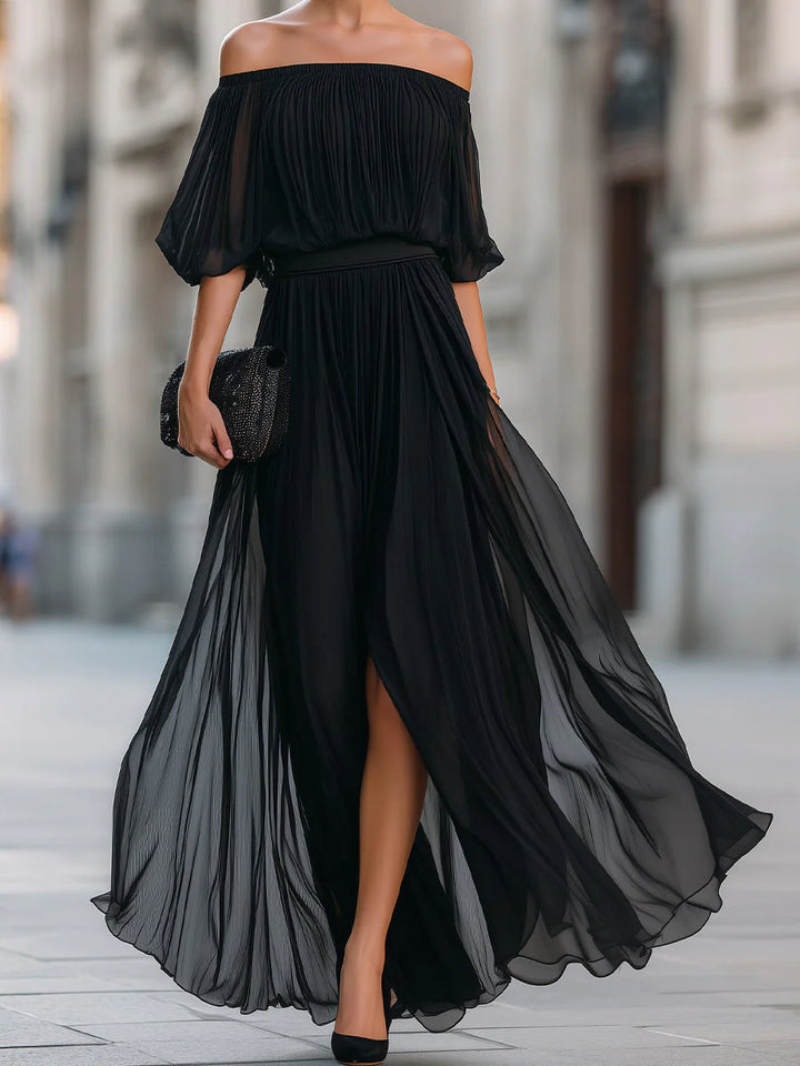Woman walking in off shoulder pleated maxi dress showing fabric movement and front slit