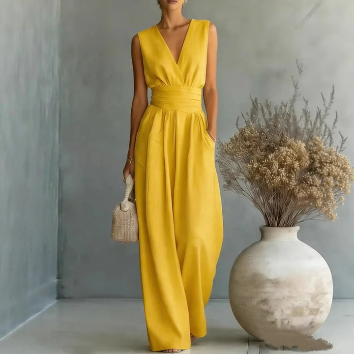 Side angle of high waist jumpsuit with V neckline and side pockets in soft blue fabric