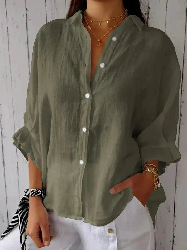 Women's Linen Summer Blouse in olive green with V-neck and button-front closure worn with white pants