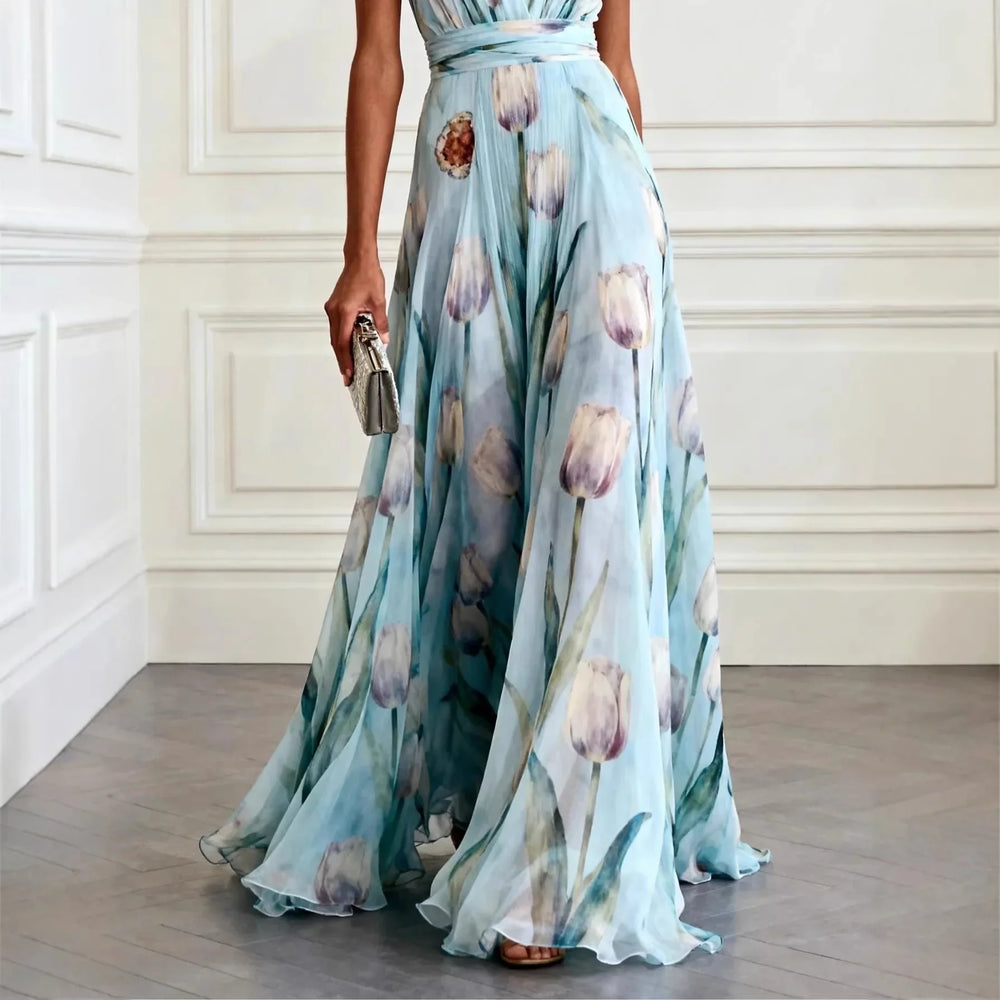 Sky blue maxi wedding guest dress with deep V-neckline and flowing skirt in elegant setting